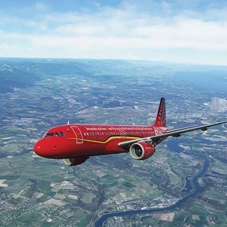 Red aircraft flying above the countryside in a flight simulator.